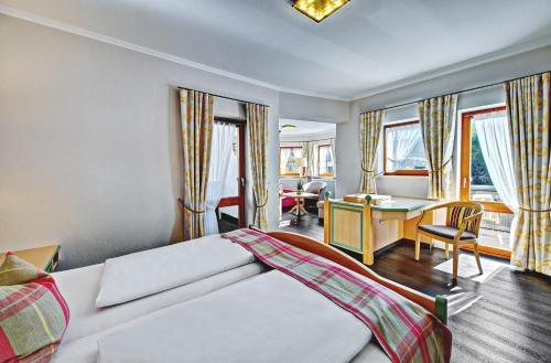 a hotel room with a bed and a desk at DIANA Naturpark Hotel - Partnerbetrieb von "Oberstaufen PLUS GOLF" in Oberstaufen