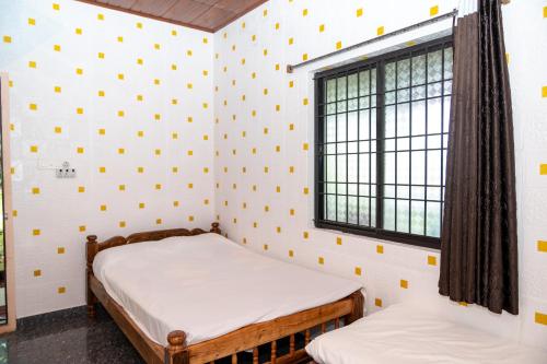 a room with two beds and a window at Isiri river side stay in Kalasa