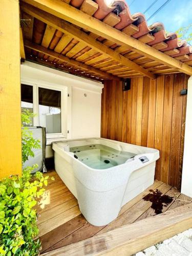 une grande baignoire assise sur une terrasse en bois dans l'établissement Casa Rochelaise - Jacuzzi, à La Rochelle