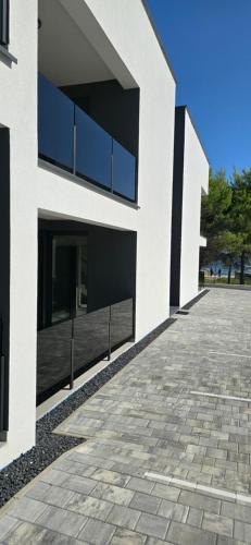a white building with a stone driveway at Miliva Apartments in Vir