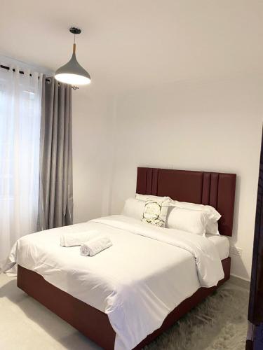 a bedroom with a large bed with white sheets at BuCci 's Cozy 1bedroom Apartment Nanyuki in Nanyuki