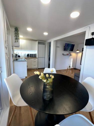 a dining room table with a vase of flowers on it at Mobile Home Luxor in Grebaštica