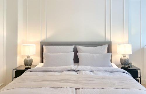 a bedroom with a large bed with two lamps at MEERBLICK-MAISONETTE Ostseebad Kühlungsborn in Kühlungsborn