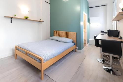 une chambre avec un lit, un bureau et un ordinateur dans l'établissement Rochefoucauld, à Rouen
