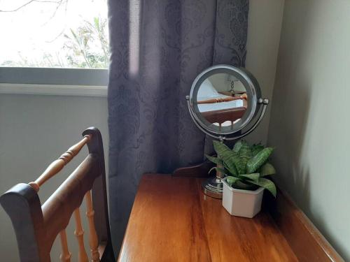 a mirror on top of a wooden table next to a window at The Loft in Mtunzini