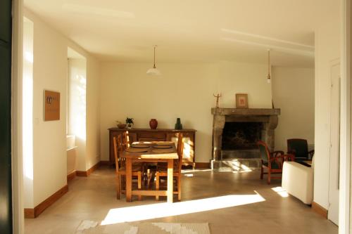 a living room with a table and a fireplace at Le Carrouge, jolie maison cancalaise in Cancale