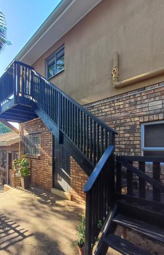 a blue staircase on the side of a brick house at The Loft in Mtunzini