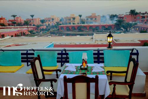 a table and chairs with a view of a city at MG Alexander The Great Hotel in Marsa Alam City