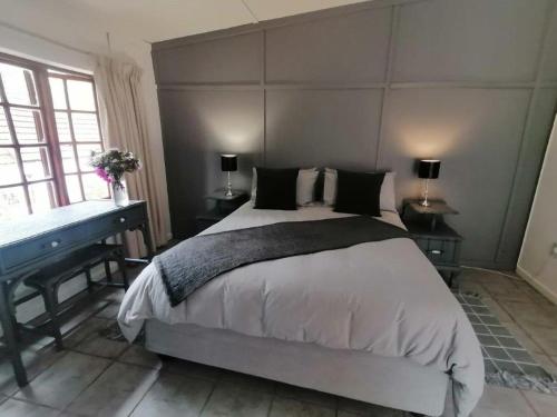 a bedroom with a large bed and a piano at Kings Lodge Hotel in Hogsback