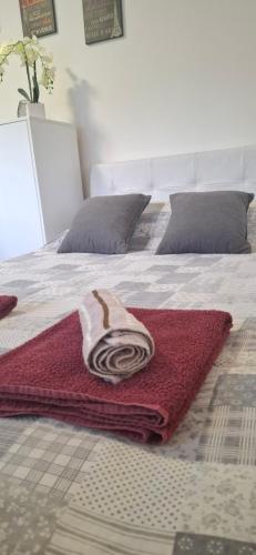 a bed with a red and white blanket on it at APARTMENTS IVANOViC CENTER CITY in Bajina Bašta
