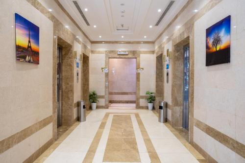 a hallway in a building with two potted plants at فندق سيف بلص 2 من اورفانا in Makkah