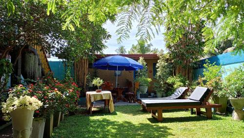 a patio with a table and a blue umbrella at Raj Mahal Inn in Wadduwa