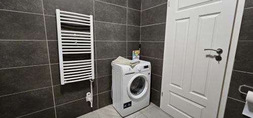 a bathroom with a washing machine and a white door at MVA House Teplice, Šanovský park in Teplice