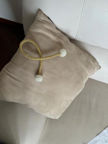 a white pillow with a gold ribbon on it at Terrazza dei fiori in Cesano