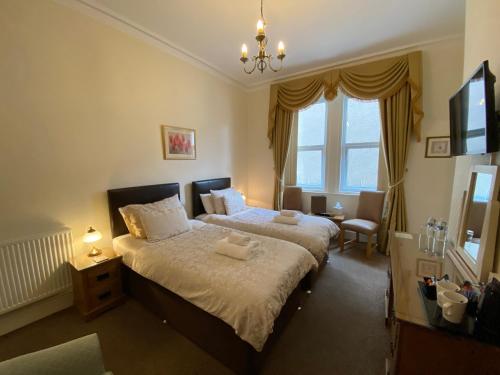 a bedroom with a large bed and a window at Cedar Lodge in Llandudno