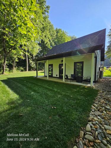 a house with a patio and a grass yard at Life's Good Retreat Bear Cottage in Brevard