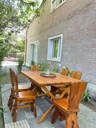 a wooden table and chairs sitting in front of a building at Duplex Las Margaritas Bosque Peralta Ramos in Mar del Plata