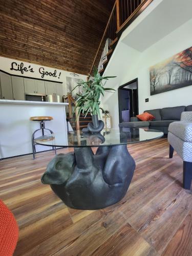 a living room with a glass table with a plant on it at Life's Good Retreat Bear Cottage in Brevard