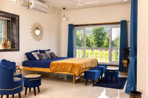 a bedroom with a bed and blue chairs at Prana Healing House in Pune