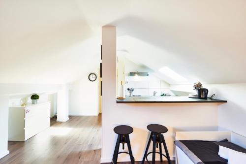 une chambre avec deux tabourets de bar et une cuisine dans l'établissement RM 3 Studio tout mignon 1 personne 3ème étage, à Mulhouse