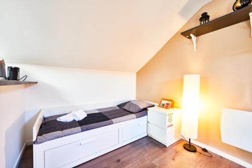 une petite chambre avec un lit et un bureau dans l'établissement RM 3 Studio tout mignon 1 personne 3ème étage, à Mulhouse