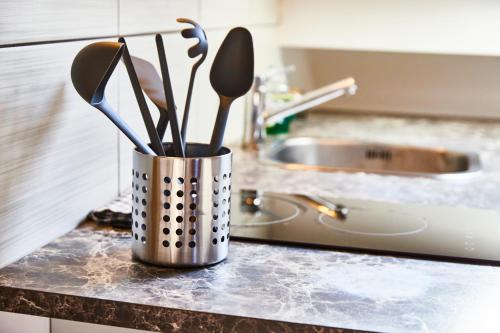 un récipient d'ustensiles sur un comptoir dans une cuisine dans l'établissement RM 3 Studio tout mignon 1 personne 3ème étage, à Mulhouse