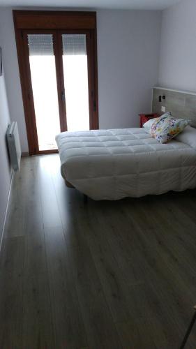 a bedroom with a large bed and a wooden floor at La Casa de los Soportales in Mansilla de las Mulas