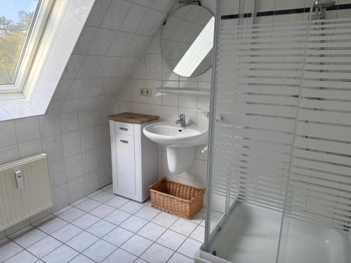 a bathroom with a sink and a glass shower at Ferienwohnung Seeigel in Prerow