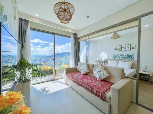 a living room with a couch and a large window at The Song Luxury Apartment Vung Tau - Siêu ưu đãi chỉ có trong tuần nay in Vung Tau