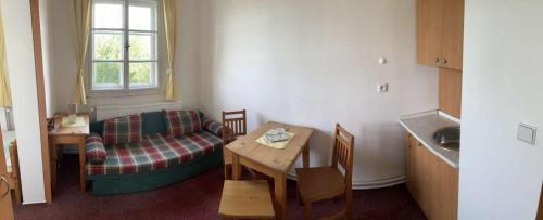a living room with a couch and a table and a kitchen at Chata Maxe Švabinského in Česká Třebová