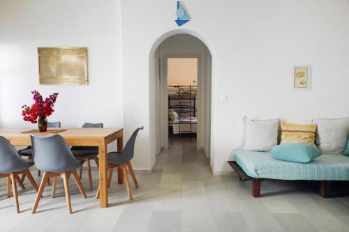 a dining room with a table and a couch and a table and chairs at casa maia in Kampos Paros