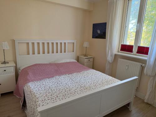 a bedroom with a white bed and two windows at Ferienwohnung Möövnest in Prerow