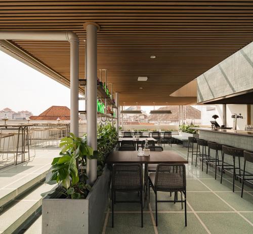 a restaurant with tables and chairs on a patio at Maison Wilhelmina in Bandung