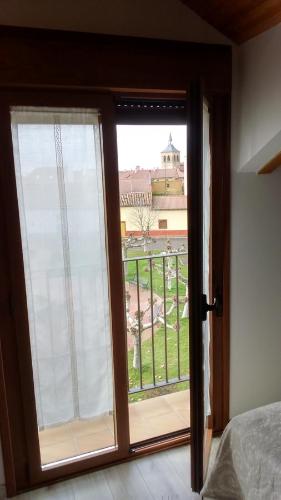 a sliding glass door with a view of a building at La Casa de los Soportales in Mansilla de las Mulas