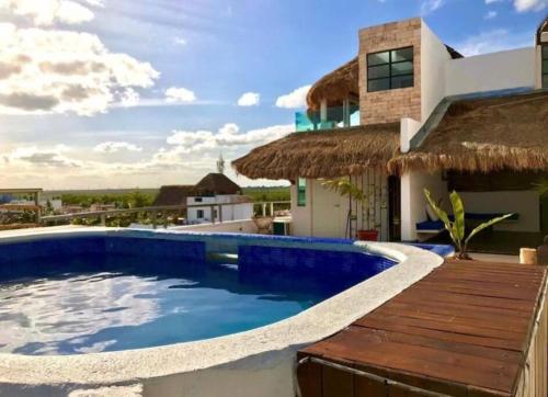 a swimming pool with a deck and a house at Bonita habitación con pequeña piscina a aire libre in Puerto Morelos