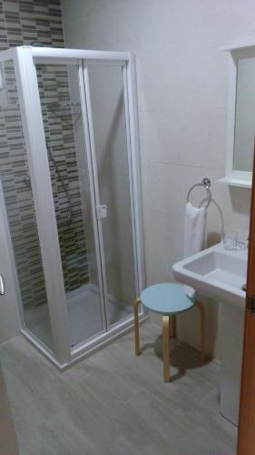 a bathroom with a glass shower and a sink at La Casa de los Soportales in Mansilla de las Mulas