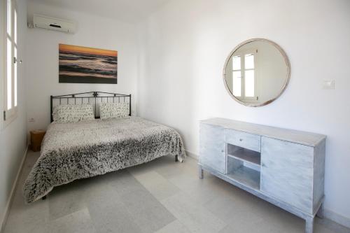 a bedroom with a bed and a mirror and a dresser at casa maia in Kampos Paros