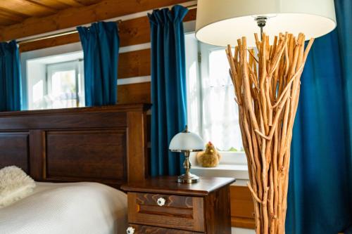 a bedroom with blue curtains and a bed and a chandelier at Luxusní apartmán s krbem - Kunratické Švýcarsko in Kunratice