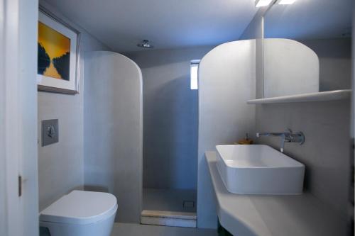 a white bathroom with a sink and a toilet at casa maia in Kampos Paros
