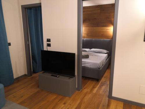 ein Wohnzimmer mit einem TV und einem Spiegel in der Unterkunft Himalaya - Apartments in Prato Nevoso