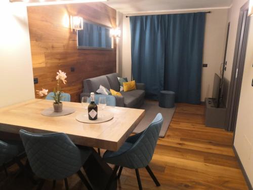 ein Esstisch und Stühle in einem Wohnzimmer in der Unterkunft Himalaya - Apartments in Prato Nevoso