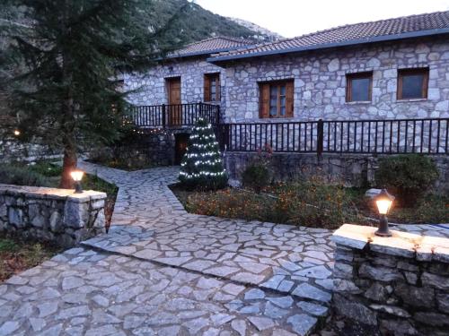 a house with a christmas tree in the yard at Andrea Sofi Guesthouse in Dhimitsana