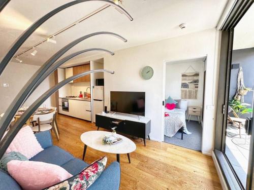 Una sala de estar con un sofá azul y una mesa. en RS703 - Serenity CBD View 1B with Balcony, Free Parking, VIC Market, Southern Cross, en Melbourne