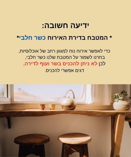a table with two stools in front of a window at סלעית 8 in Mitzpe Ramon