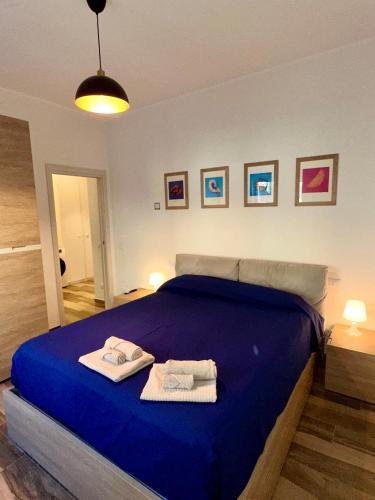 a bedroom with a blue bed with towels on it at Rainbow Luxury Home Bari in Bari