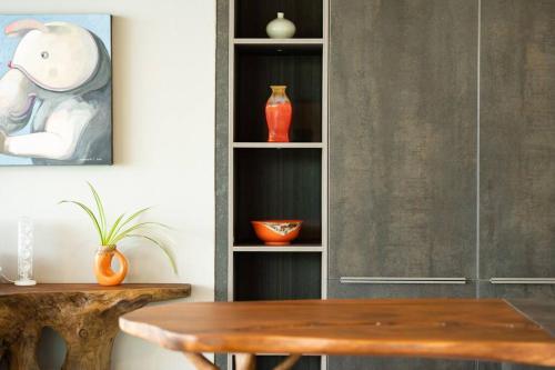 a dining room with a table and a shelf with vases at 班塔莱海滨之家1号 in Koh Samui
