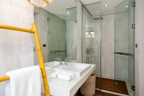 a white bathroom with a sink and a shower at 班塔莱海滨之家1号 in Koh Samui