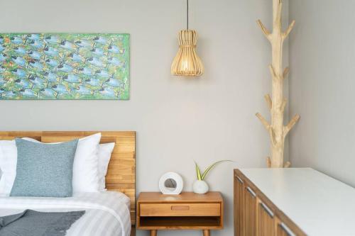 a bedroom with a bed and a painting on the wall at 班塔莱海滨之家1号 in Koh Samui