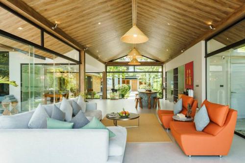 an open living room with orange and gray furniture at 班塔莱海滨之家1号 in Koh Samui
