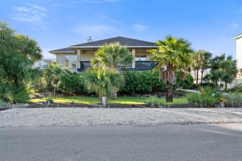 a house with palm trees in front of a street at Panferio SeaCret in Pensacola Beach